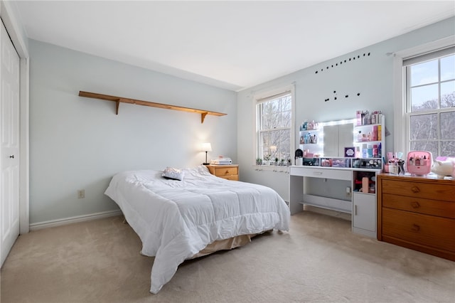 carpeted bedroom featuring multiple windows and a closet