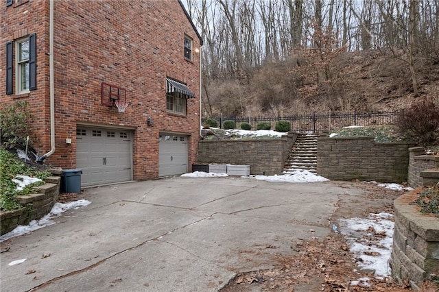 view of snow covered exterior featuring a garage