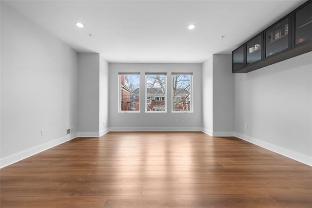 empty room with dark hardwood / wood-style flooring