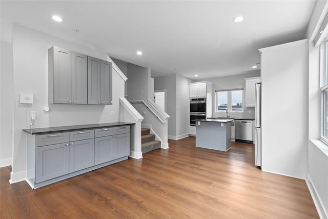 kitchen featuring hardwood / wood-style flooring, gray cabinets, and appliances with stainless steel finishes