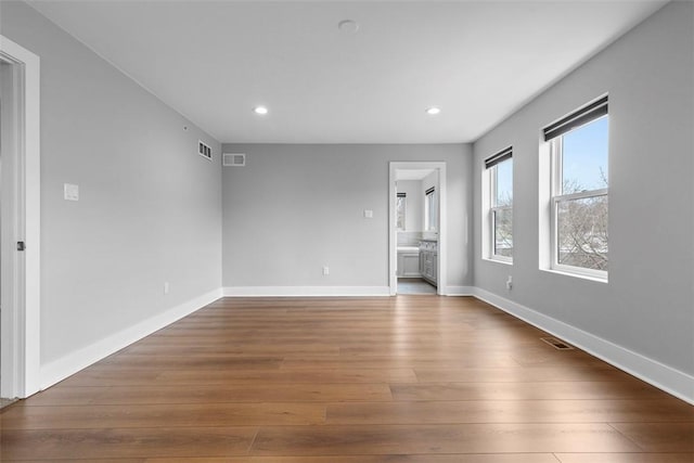 interior space with ensuite bathroom and hardwood / wood-style floors