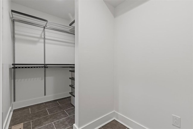 spacious closet featuring dark tile patterned flooring