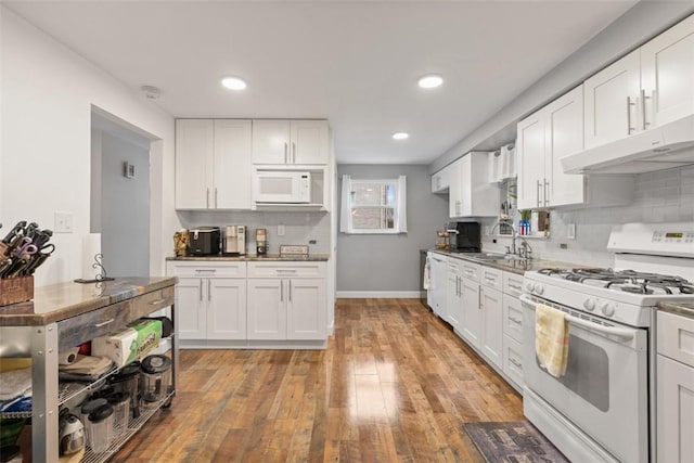 kitchen featuring white cabinetry, backsplash, and white appliances