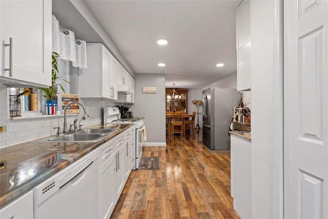 kitchen featuring white cabinetry, sink, white appliances, and decorative backsplash