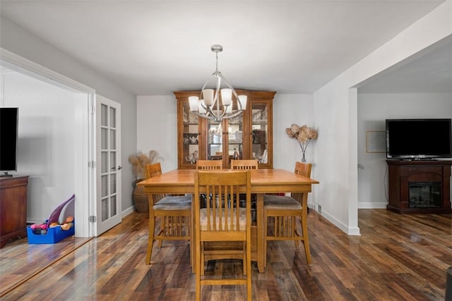 dining room featuring french doors, dark hardwood / wood-style flooring, and an inviting chandelier