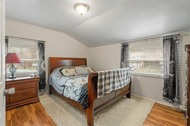 bedroom featuring hardwood / wood-style flooring and lofted ceiling