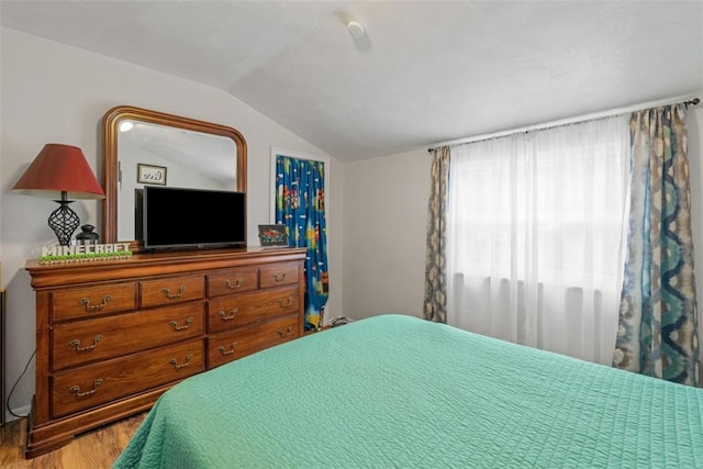 bedroom featuring lofted ceiling and light hardwood / wood-style floors