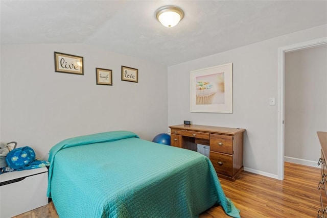 bedroom featuring vaulted ceiling and light hardwood / wood-style floors