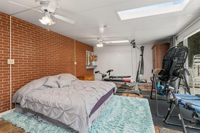 bedroom with wood-type flooring, ceiling fan, and brick wall