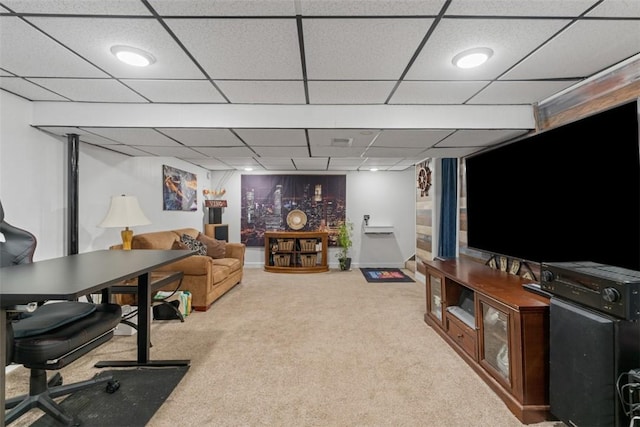 carpeted living room featuring a drop ceiling