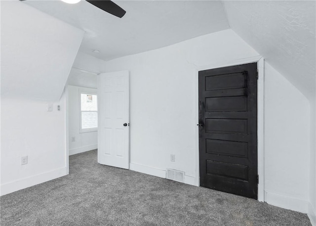 additional living space with vaulted ceiling, carpet flooring, and ceiling fan