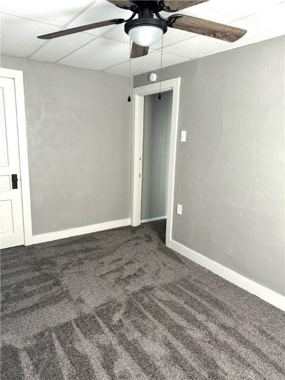 spare room with carpet floors, a drop ceiling, and ceiling fan