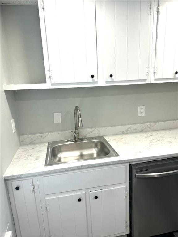 kitchen with dishwasher, sink, white cabinets, and light stone counters