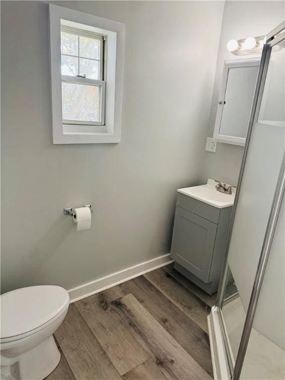 bathroom with vanity, a shower, hardwood / wood-style floors, and toilet