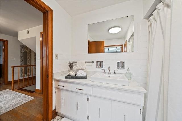 bathroom featuring vanity, hardwood / wood-style floors, and backsplash