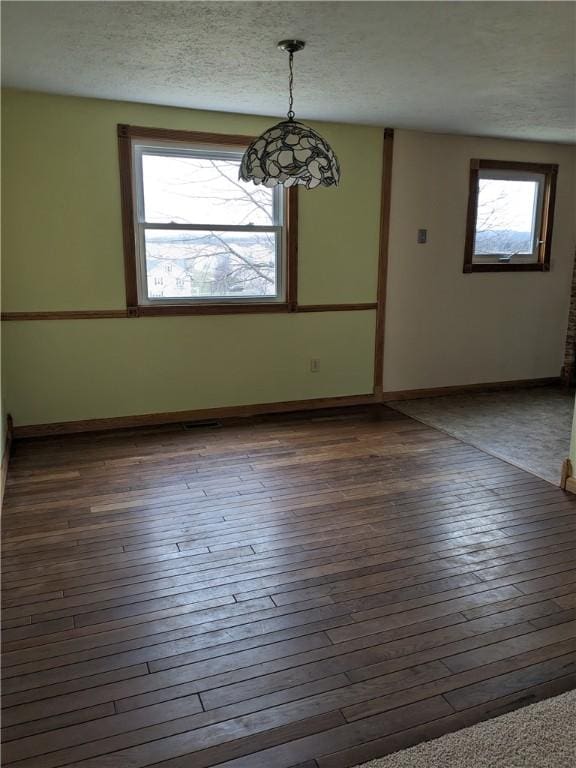 empty room featuring dark hardwood / wood-style floors and a textured ceiling