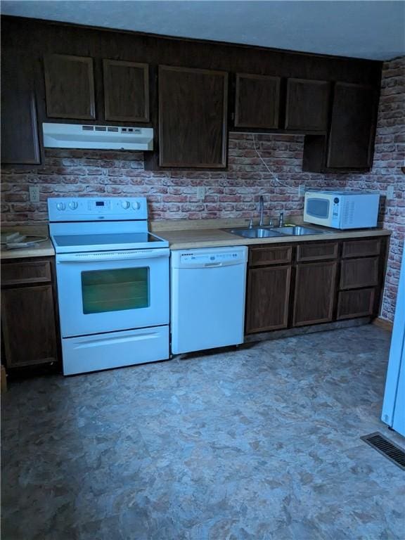 kitchen featuring dark brown cabinetry, sink, and white appliances