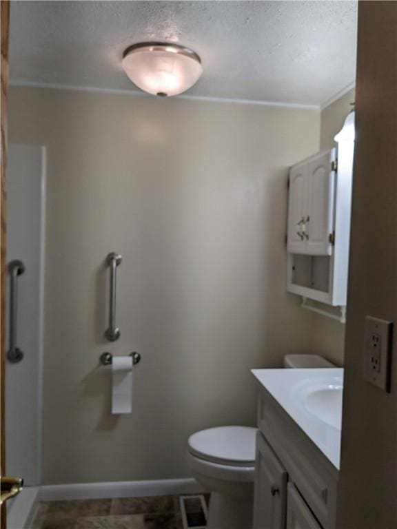 bathroom featuring crown molding, vanity, toilet, and a textured ceiling