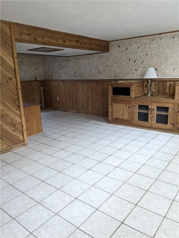 unfurnished living room featuring beam ceiling and wood walls