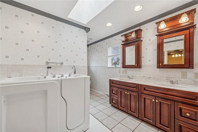 bathroom with crown molding, tile patterned flooring, tile walls, a skylight, and vanity