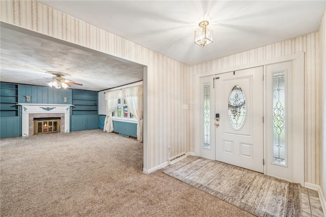 foyer with ceiling fan and carpet floors