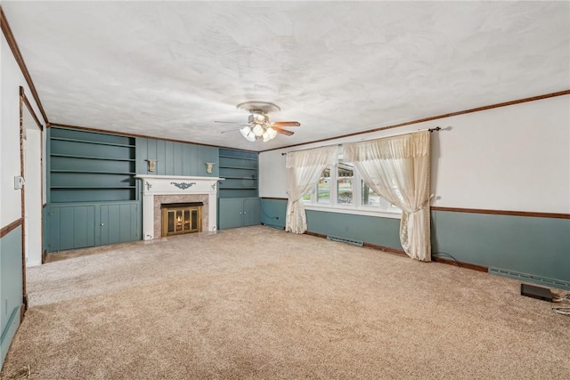 unfurnished living room featuring crown molding, carpet, a textured ceiling, and ceiling fan