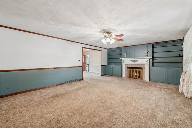 unfurnished living room featuring crown molding, a fireplace, a textured ceiling, and carpet