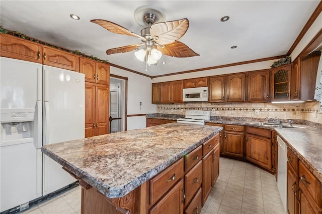 kitchen featuring sink, white appliances, tasteful backsplash, ornamental molding, and a kitchen island