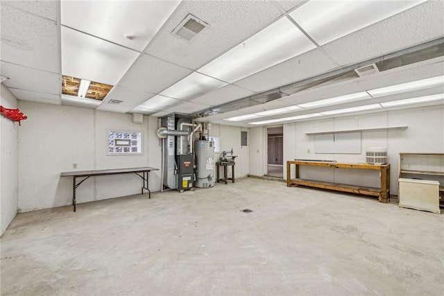 basement featuring water heater, heating unit, and a drop ceiling