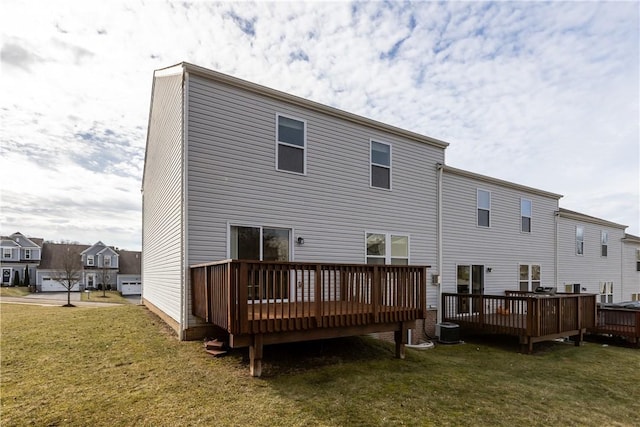 back of property with cooling unit, a wooden deck, and a yard