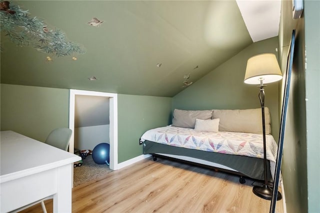 bedroom featuring lofted ceiling and light hardwood / wood-style floors