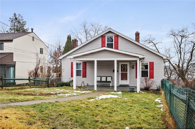 bungalow featuring covered porch and a front lawn