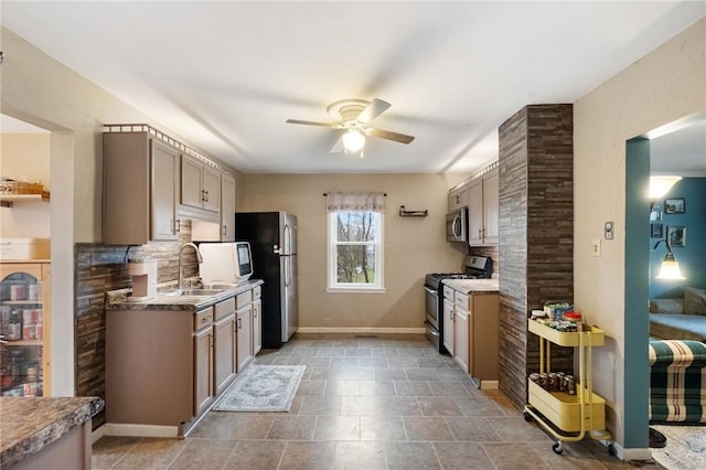 kitchen with ceiling fan, stainless steel appliances, sink, and backsplash