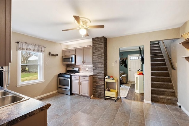 kitchen featuring backsplash, stainless steel appliances, sink, and ceiling fan