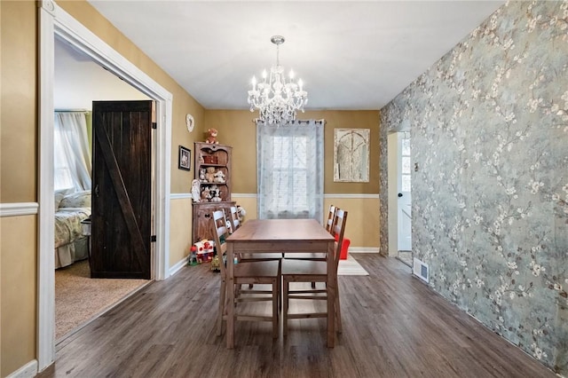 dining space featuring dark hardwood / wood-style floors and an inviting chandelier