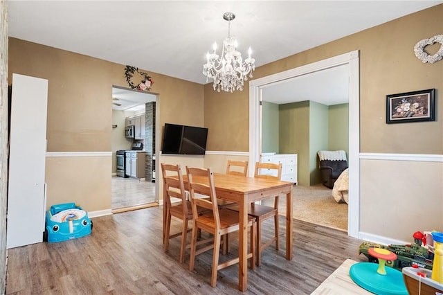 dining space with an inviting chandelier and hardwood / wood-style floors