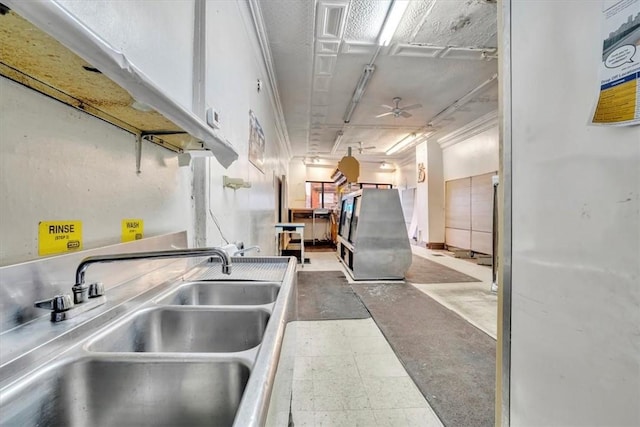 kitchen with white cabinetry, sink, and concrete flooring