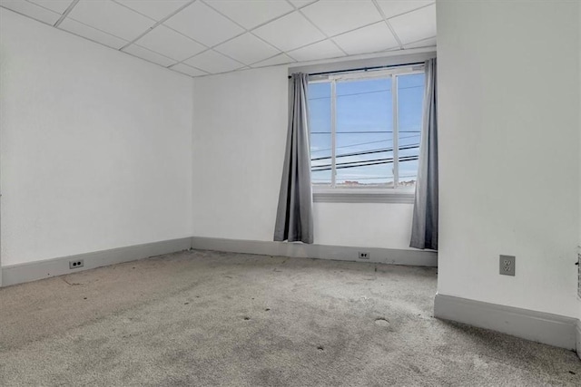 carpeted spare room with a drop ceiling