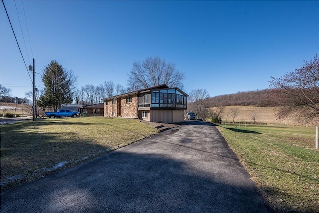 view of front of house featuring a sunroom and a front yard