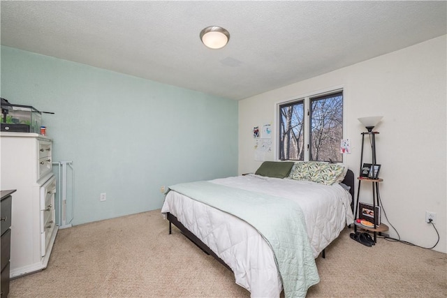 bedroom with light colored carpet and a textured ceiling