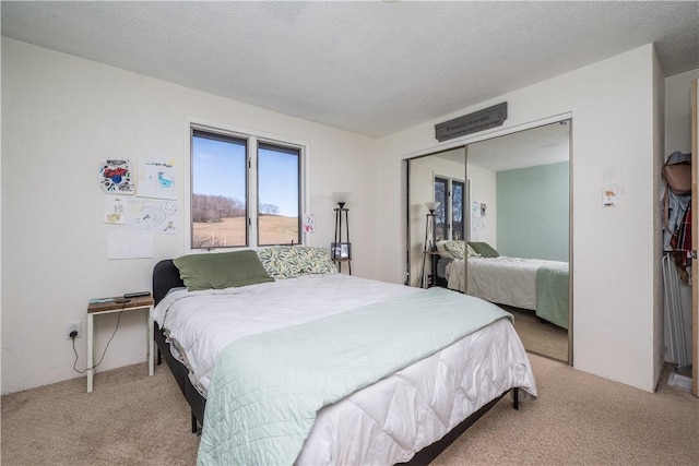 carpeted bedroom with a closet and a textured ceiling