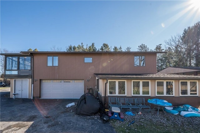 rear view of property featuring a garage