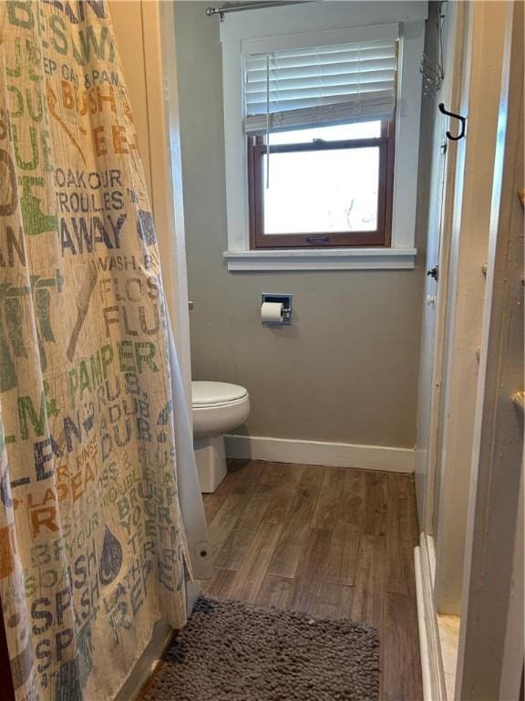 bathroom with wood-type flooring, toilet, and walk in shower