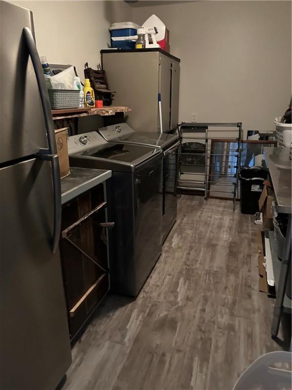 clothes washing area featuring washing machine and dryer and dark hardwood / wood-style floors