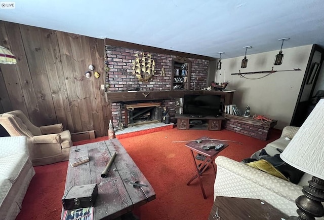 living room with a brick fireplace, dark colored carpet, and wood walls