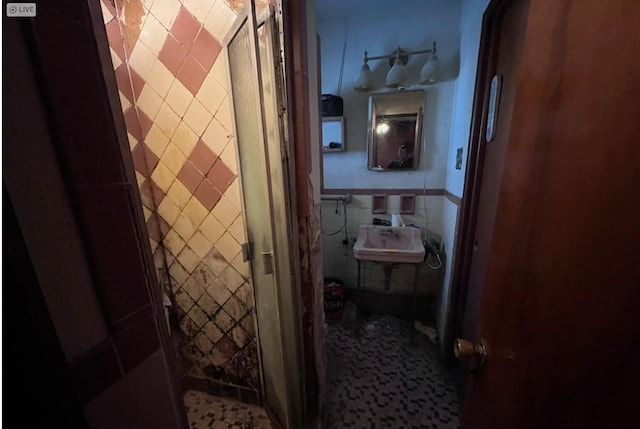 corridor featuring tile walls and sink