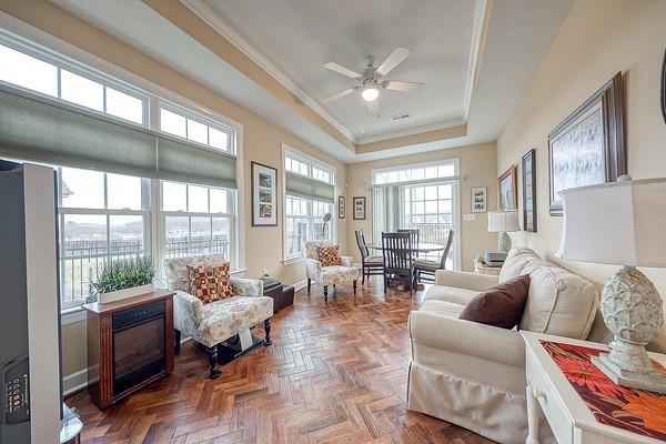 sunroom / solarium featuring ceiling fan and a raised ceiling