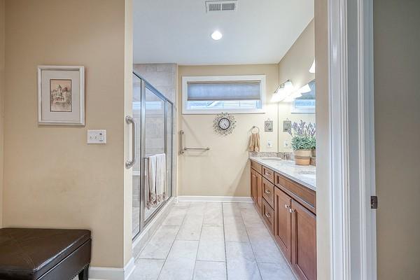 bathroom with vanity, an enclosed shower, and tile patterned flooring