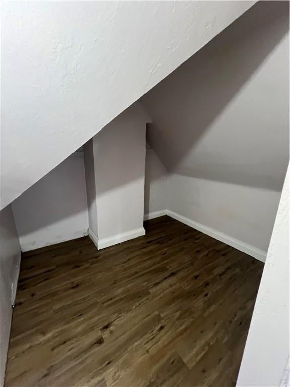 bonus room with vaulted ceiling and dark hardwood / wood-style floors