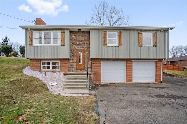 split foyer home with a garage and a front lawn